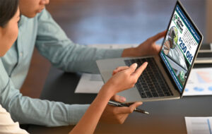 two people looking at a display ad on a laptop. place digital display ads in reputable publications