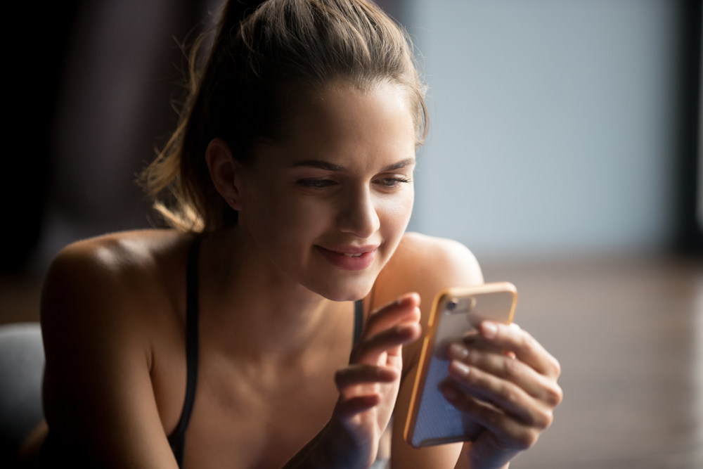 person in work out attire looking at their phone Display Advertising for health care industries in print or online