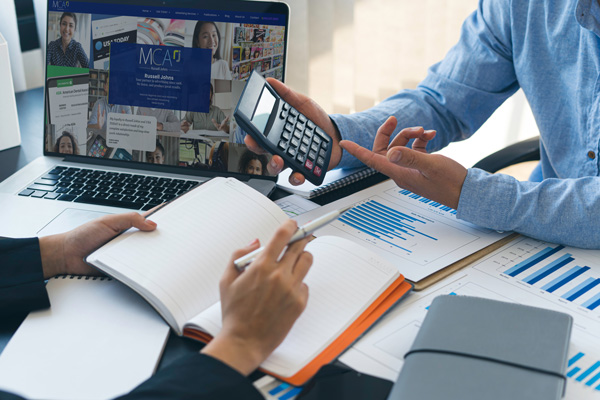 People working on accounting and billing with a computer in the background