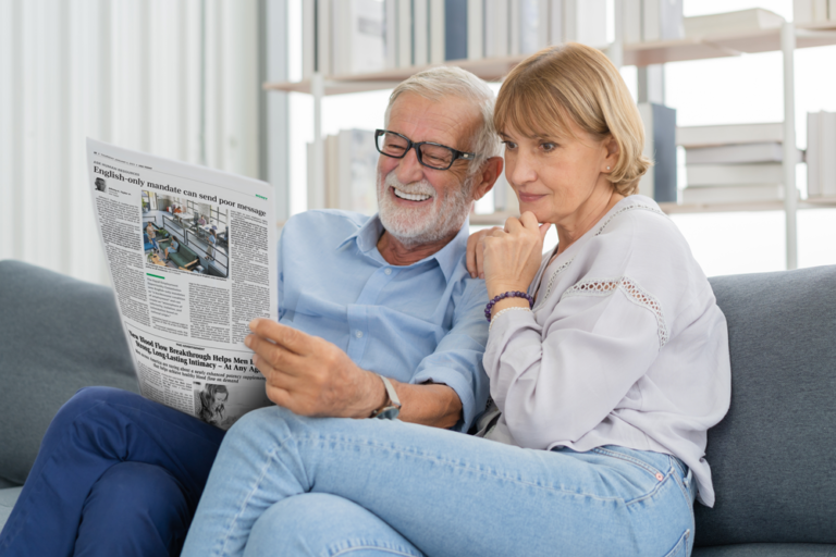 Two people reading a copy of USA today , USA Demographics readers are highly educated from above average income households