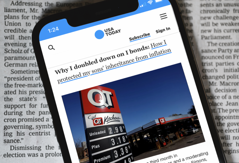 Mobile phone sitting on Top of a newspaper with article from USA Today ; USA digital Advertising